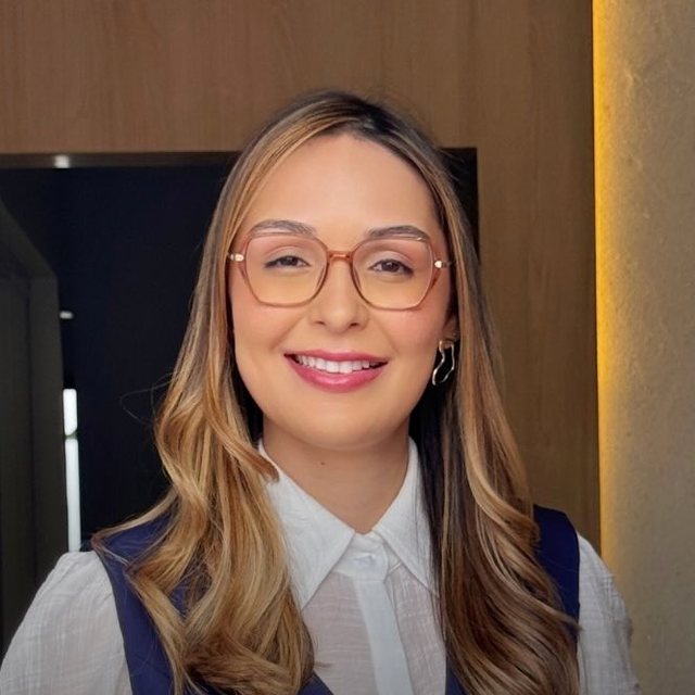 Retrato da advogada Layanne Vitório, de óculos e colete azul-marinho
